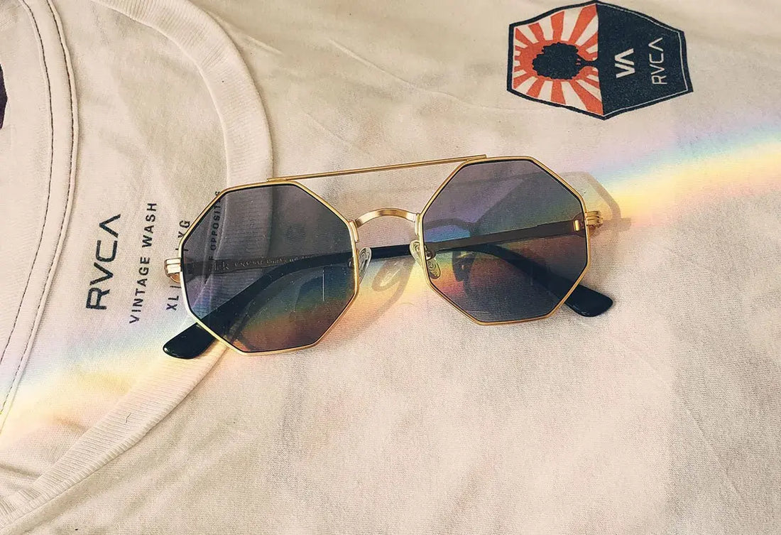 Beautiful cat eye glasses with colored lenses and gold frames, stylish eyewear on fabric